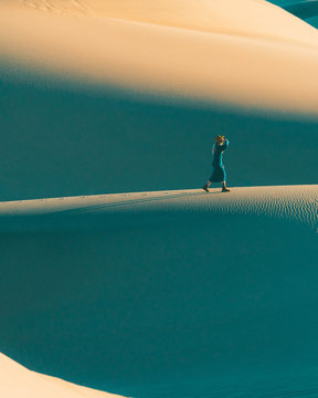 Woman walking on sand dunes
