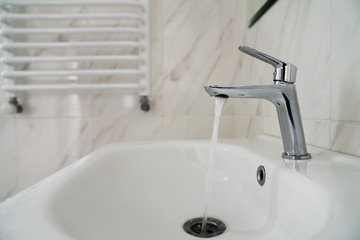 Water flowing from the faucet with sink. The water is not running. Water shortage.