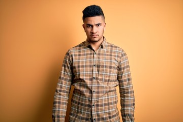 Young handsome man wearing casual shirt standing over isolated yellow background depressed and worry for distress, crying angry and afraid. Sad expression.