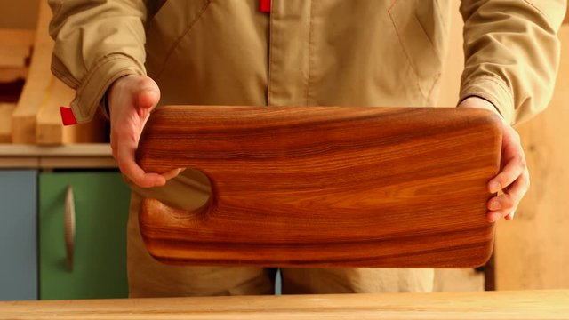 Joiner showing beautiful dark cutting board from elm wood