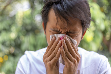 Young man coughed up the blood on tissues, ill man with bloody cough