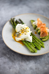 Green asparagus with poached egg, avocado , creme cheese and salmon on a plate