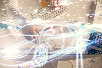 Double exposure of man's hands typing over computer keyboard and automobile theme hologram drawing. Top view. Technology concept.