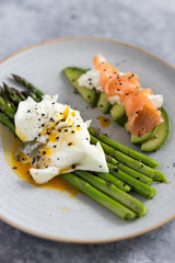 Green asparagus with poached egg, avocado , creme cheese and salmon on a plate