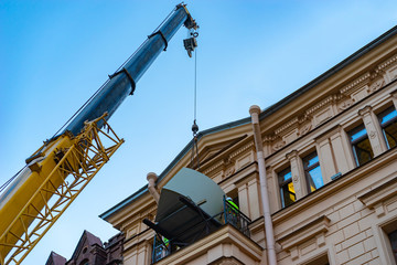 Descent of large objects from the apartment through the balcony. Construction lift helps to lower large furniture. Loading and unloading in construction.