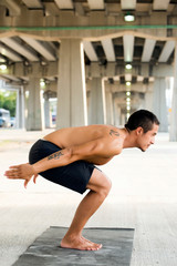 Fototapeta na wymiar Mexican man practicing yoga in a urban background
