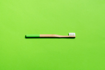 lime green bamboo toothbrush on a green background. eco friendly. isolate