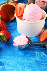 Strawberry ice cream scoop with fresh strawberries and waffle icecream cones