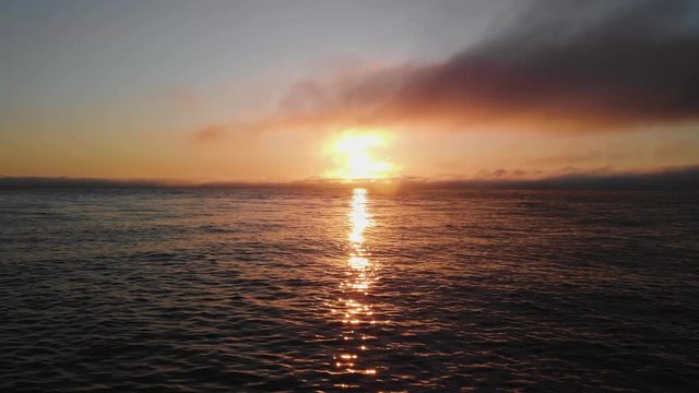 Beautiful sunrise sunset clouds over columbia river in astoria oregon sun shining brightly on waves landscape