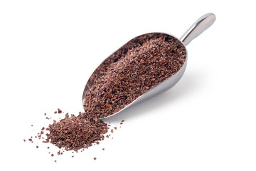 Chocolate chip cocoa beans in a silver spoon on a white background