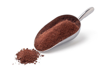 Chocolate chips in a silver spoon on a white background
