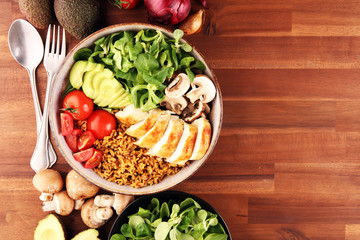 Healthy salad bowl with quinoa, tomatoes, chicken, avocado and mixed greens, lettuce. Food and health bowl