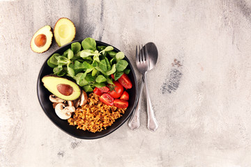 Healthy vegan salad bowl with quinoa, tomatoes, avocado and mixed greens, lettuce. Food and health bowl