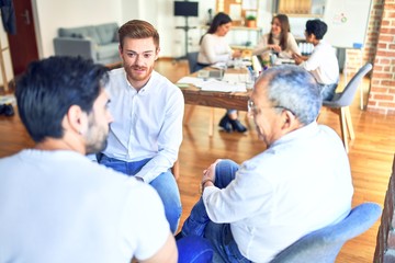 Handsome businessmen smiling happy. Sitting with smile on face speaking taking rest at the office