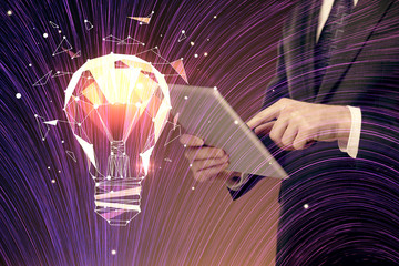 Double exposure of man's hands holding and using a digital device and bulb hologram drawing. Idea concept.