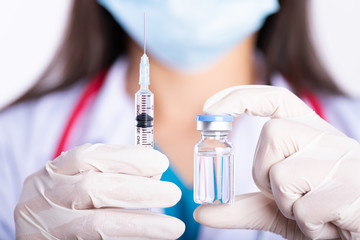 Female doctor with a stethoscope on shoulder holding syringe and vaccine. Healthcare And Medical concept.