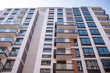 Beautifully designed multistory house with glass facade balconies in city district architecture, luxury real estate property apartments for sale.