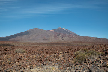 Pico del Teide and Pico Viejo in Teide National Park surrounded by the arid landscape created by volcanic eruptions: igneous rocks, solidified lava and volcanic ash, in Tenerife, Canary Islands, Spain