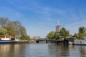 Fototapeta na wymiar Windmill overlooking the canal