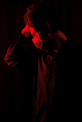 masked doctor in a dark room with red light