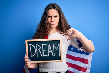 Beautiful patriotic woman wearing united states flag holding blackboard with dream message with...