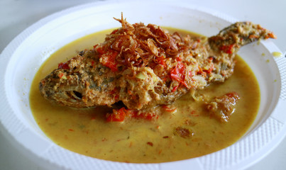 Pecak mujair or Mozambique tilapia on white background. Spicy Indonesian cuisine.