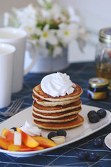Breakfast pancakes served with honey and fruits