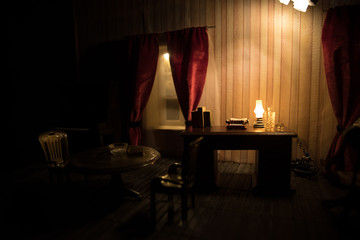 A realistic dollhouse living room with furniture and window at night. Artwork table decoration with handmade realistic dollhouse.