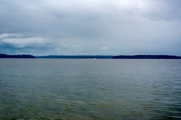 Small boat sailing Puget Sound on cloudy day