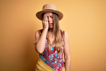 Young beautiful blonde woman wearing swimsuit and summer hat over yellow background Yawning tired...