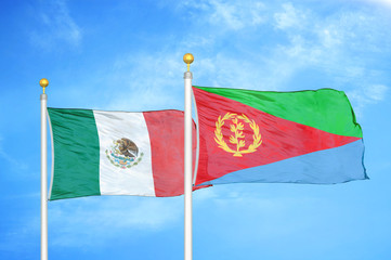 Mexico and Eritrea two flags on flagpoles and blue cloudy sky