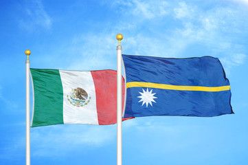 Mexico and Nauru two flags on flagpoles and blue cloudy sky