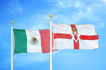 Mexico and Northern Ireland two flags on flagpoles and blue cloudy sky