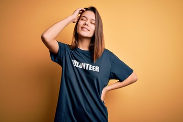Young beautiful brunette girl doing volunteering wearing t-shirt with volunteer message word...