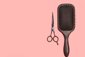 Professional black comb and scissors. Hairdresser tools on a pink pastel background. Flat lay, copyspace - obrazy, fototapety, plakaty