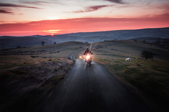 Motorcycle Ride Across Scenic Countryside At Sunrise