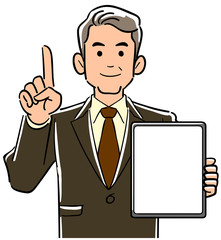 画面が空欄のタブレットPCを持ち人差し指を立てて説明するスーツ姿の管理職男性