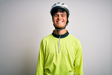 Young handsome cyclist man wearing security bike helmet over isolated white background with a happy and cool smile on face. Lucky person.