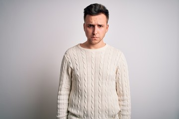 Young handsome caucasian man wearing casual winter sweater over white isolated background skeptic and nervous, frowning upset because of problem. Negative person.