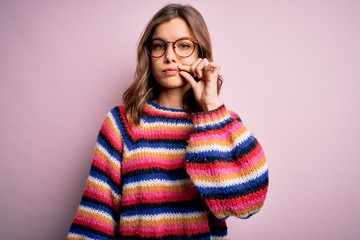 Young beautiful blonde girl wearing glasses and casual sweater over pink isolated background mouth...