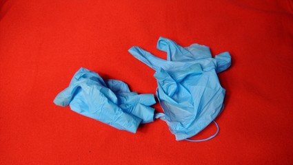 Discarded medical gloves on red background