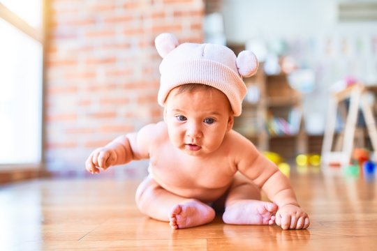 Adorable baby lying down on the sofa at home. Newborn wearing fanny hat relaxing and resting comfortable