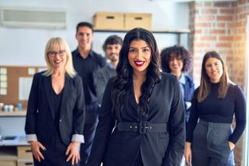 Obraz premium Group of business workers smiling happy and confident. Posing together looking at the camera, young beautiful woman with smile on face at the office