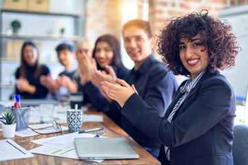 Group of business workers smiling happy and confident. Working together with smile on face looking at the camera applauding at the office