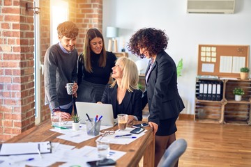 Group of business workers smiling happy and confident. Working together with smile on face  using laptop at the office