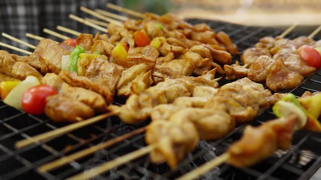 Grilled BBQ pork and chicken steaks on stove, Traditional Thai BBQ street food.