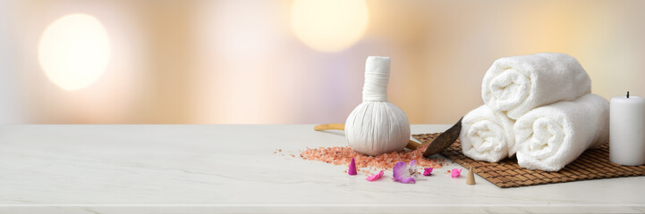 Cropped shot of Spa accessories with white towel, candle, herbal compressing ball and copy space