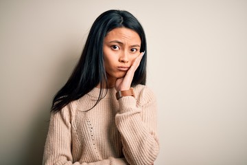 Young beautiful chinese woman wearing casual sweater over isolated white background thinking looking tired and bored with depression problems with crossed arms.