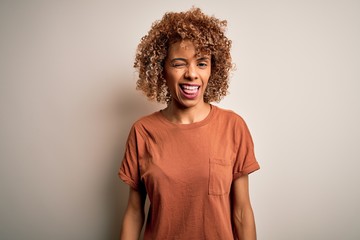 Beautiful african american woman with curly hair wearing casual t-shirt over white background...