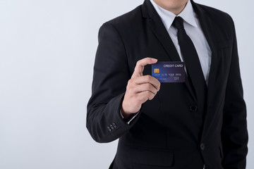 Closeup of handsome young businessman holding credit card, isolated on white background